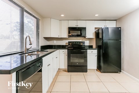 a kitchen with black appliances and white cabinets