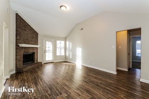 the living room with wood flooring and a fireplace