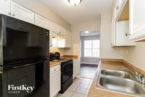 a kitchen with black appliances and white cabinets