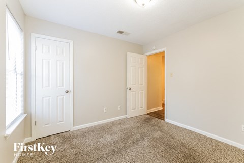 a bedroom with two white doors and a carpeted floor