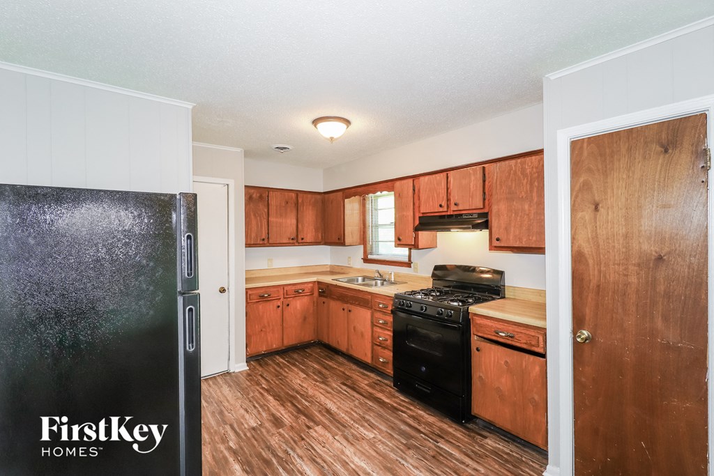 A kitchen with wooden cabinets and a black stove top oven.