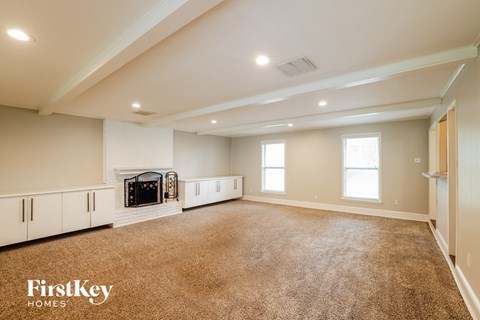 a large living room with carpet and a fireplace