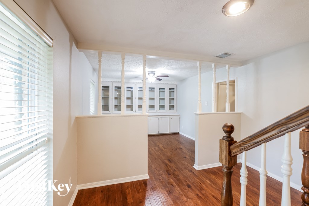 a renovated living room with white walls and a staircase