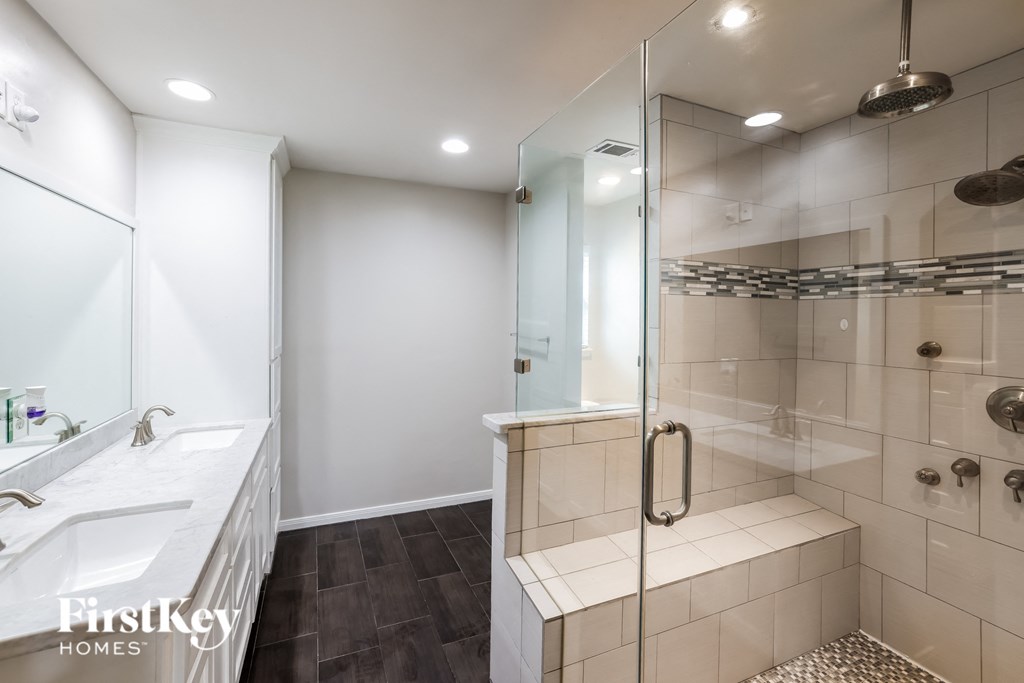 a bathroom with a shower and a sink and a mirror