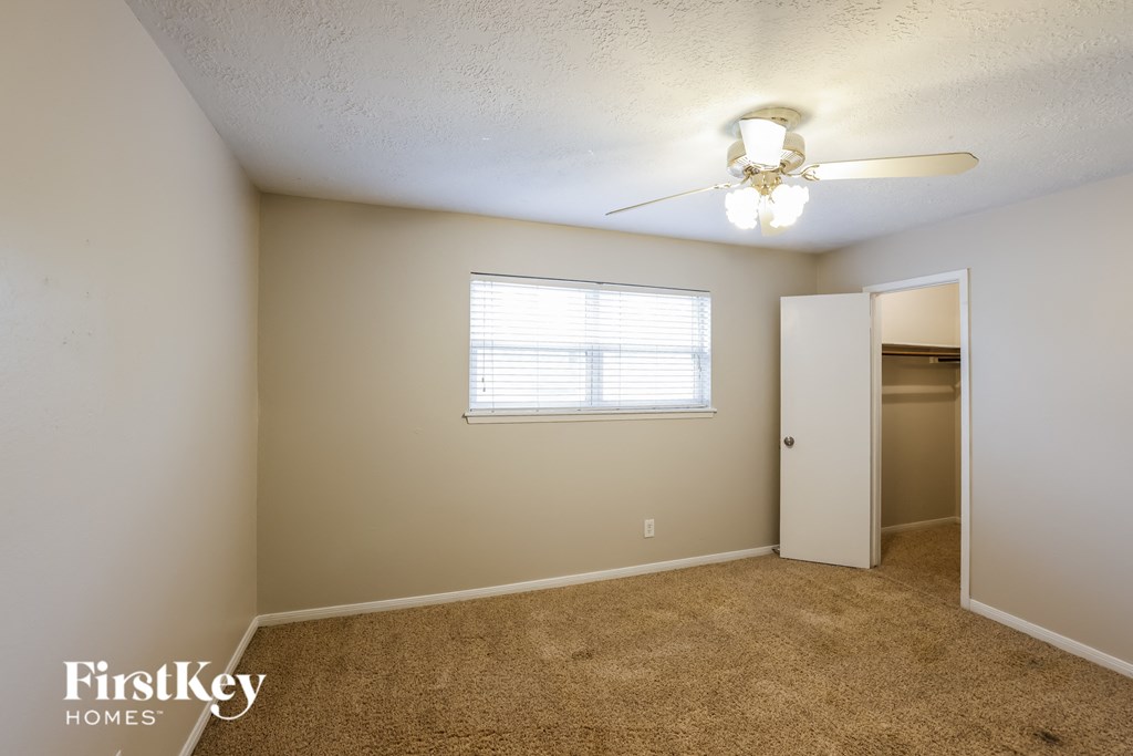 a bedroom with a closet and a ceiling fan
