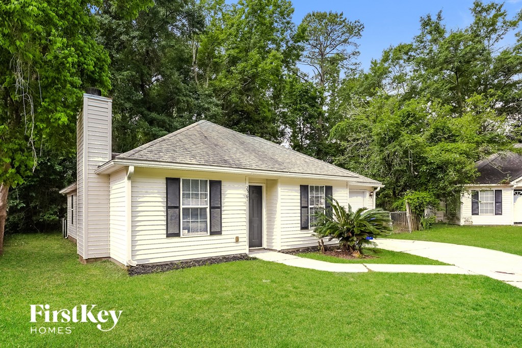 a small white house with a yard and a sidewalk