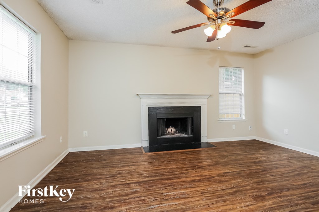 a living room with a fireplace and a ceiling fan