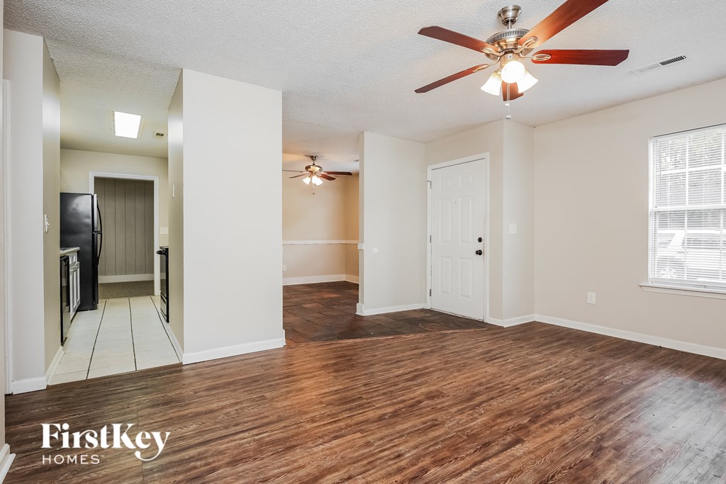 the living room and dining room with hardwood flooring and a ceiling fan
