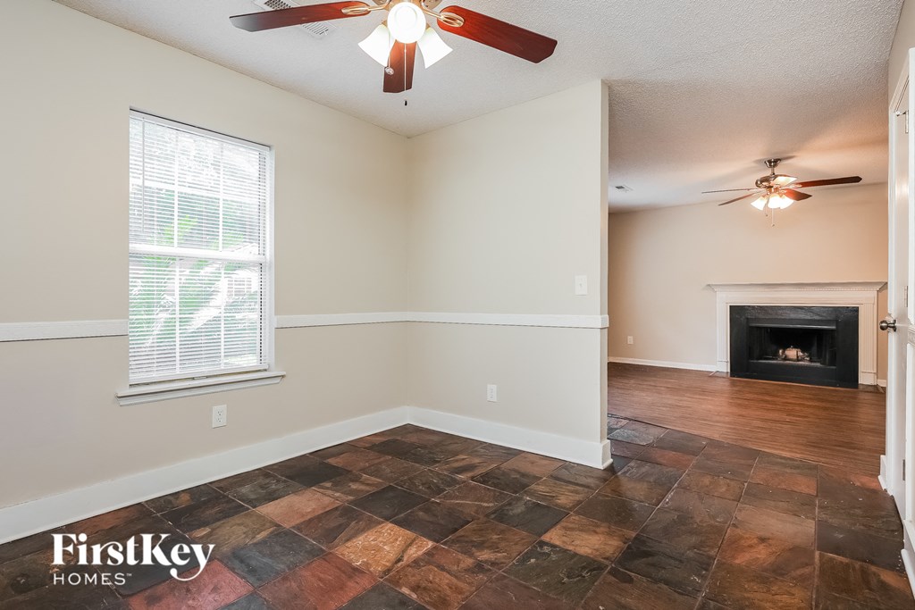a living room with a fireplace and a ceiling fan