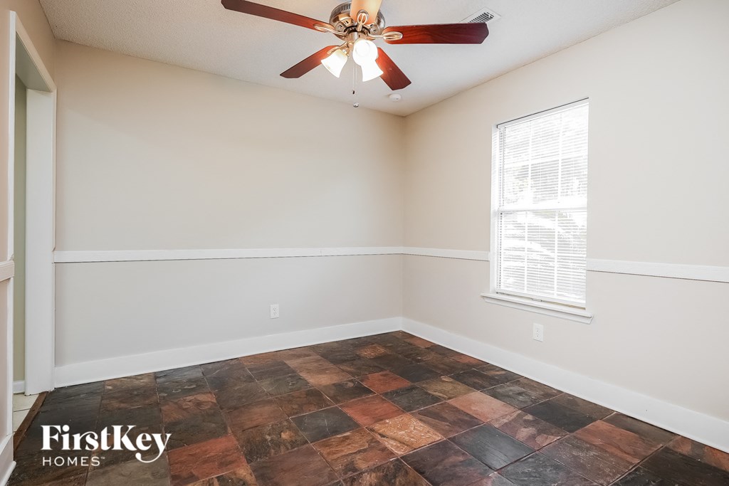 a living room with a ceiling fan and a window