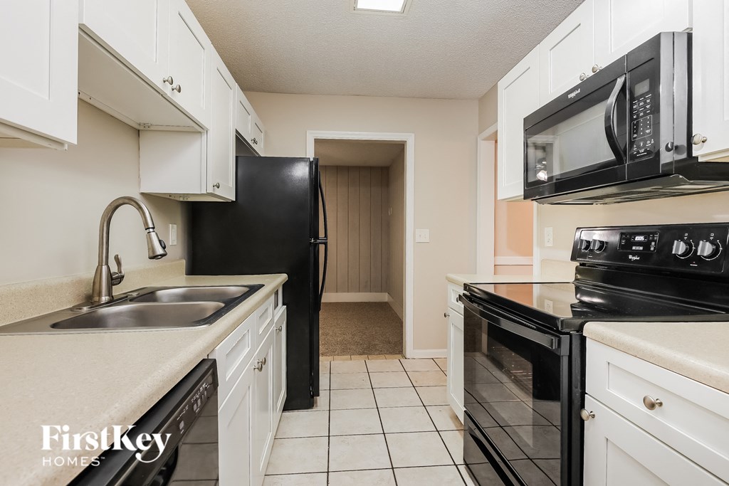a kitchen with black appliances and white cabinets