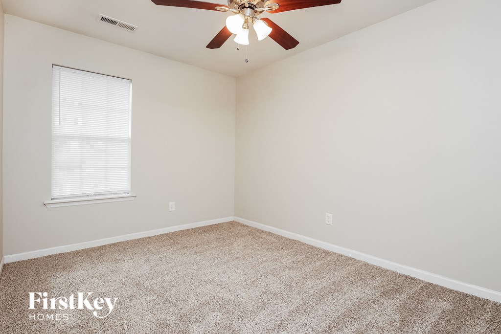 a bedroom with carpet and a ceiling fan