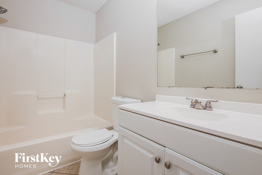 a bathroom with a sink toilet and a mirror