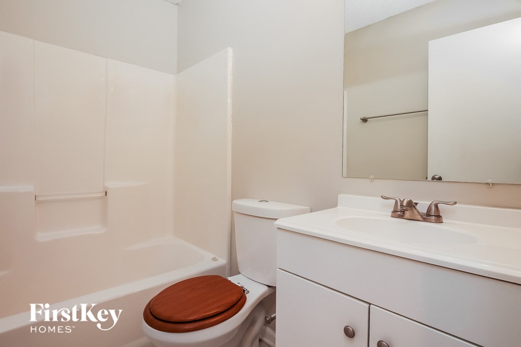 a bathroom with a toilet and a sink and a mirror
