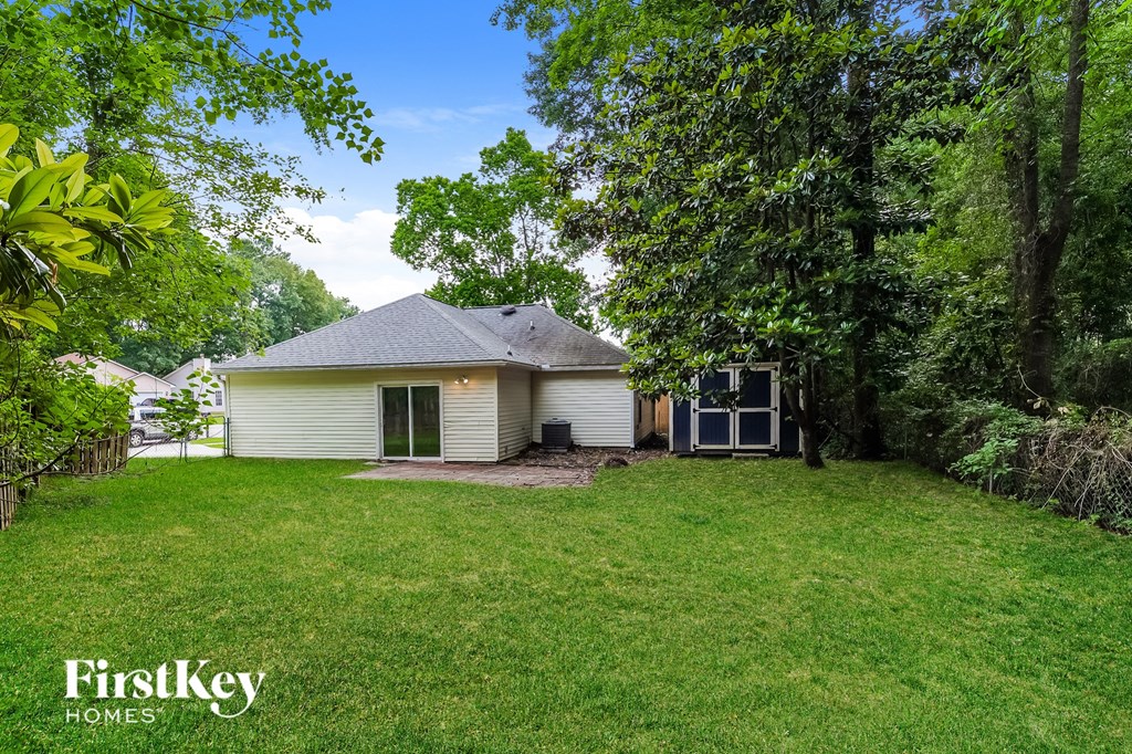a small white house with a yard and trees