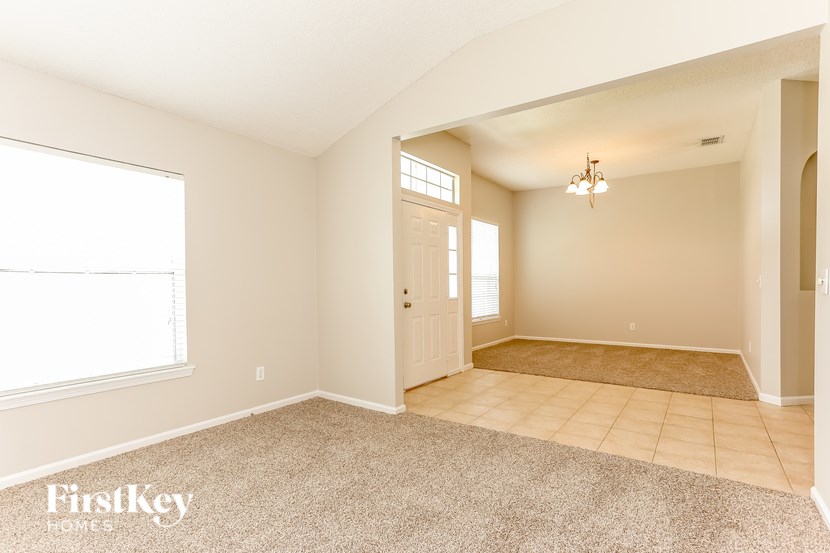 A room with a carpeted floor and a doorway leading to another room.