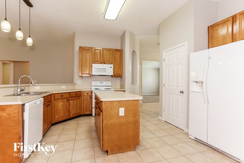 A kitchen with wooden cabinets and white appliances.