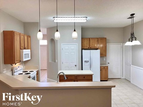 A kitchen with wooden cabinets and a white fridge.