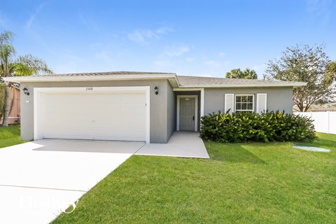 a white house with a lawn and a garage door