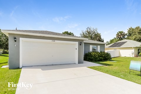 a white house with a garage door and a lawn