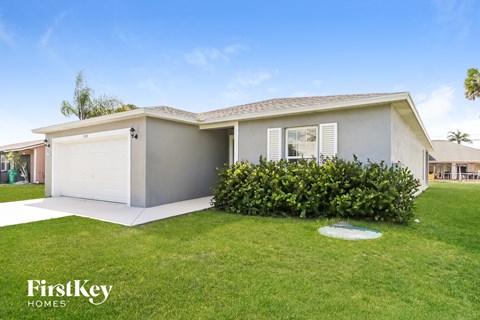 a home with a lawn and a white garage door