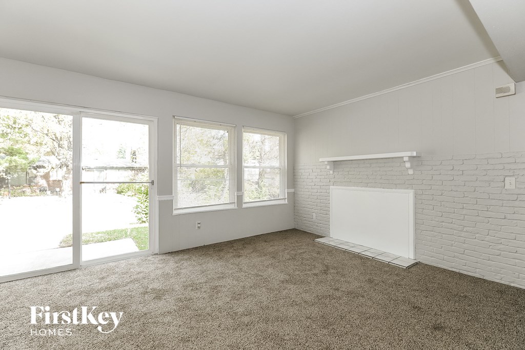 A room with a carpeted floor and a white brick wall.
