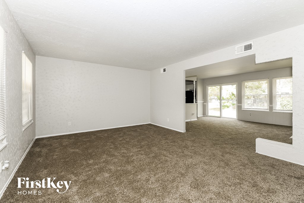 A room with a carpeted floor and a FirstKey Homes logo.