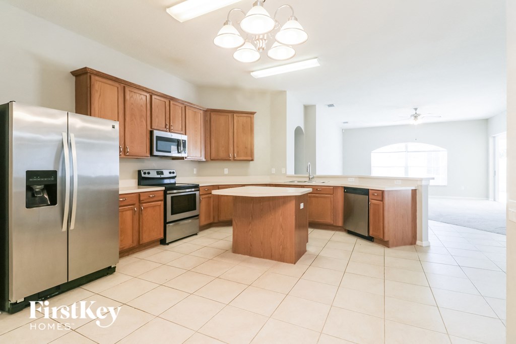 a large kitchen with wooden cabinets and stainless steel appliances