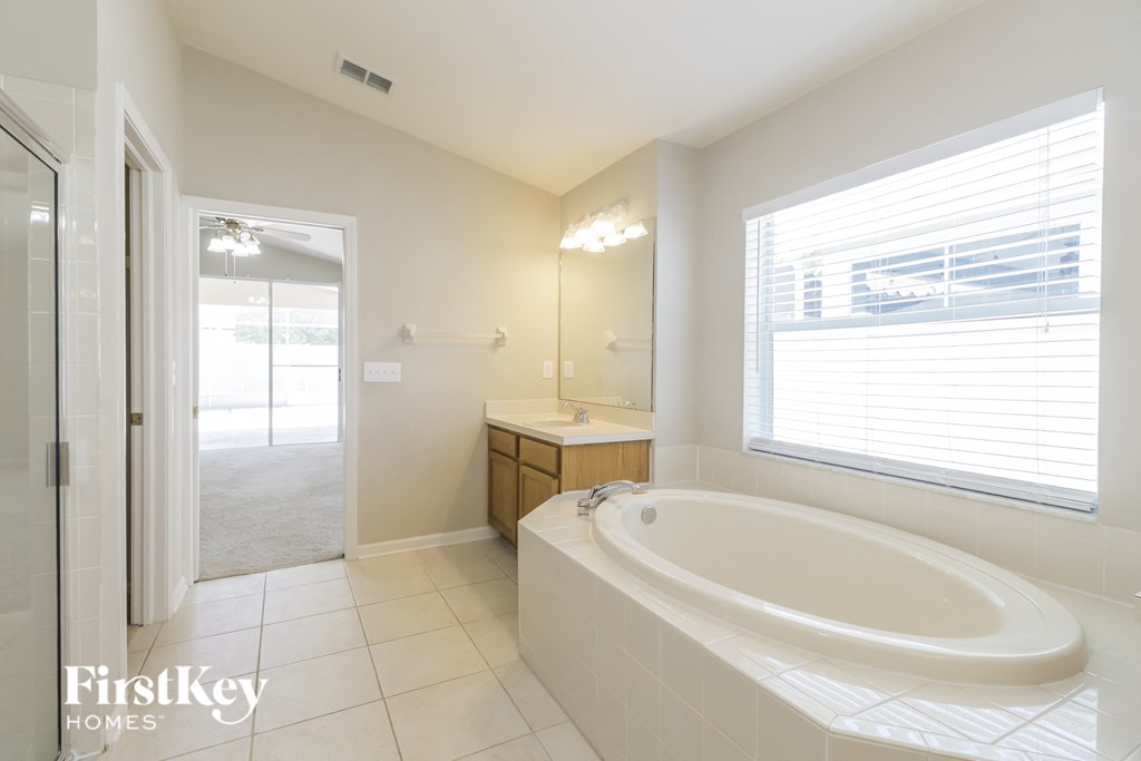 a bathroom with a large tub and a sink and a window