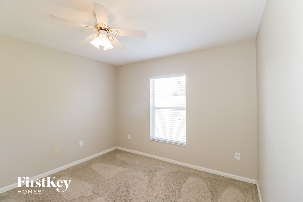 a bedroom with a ceiling fan and a window