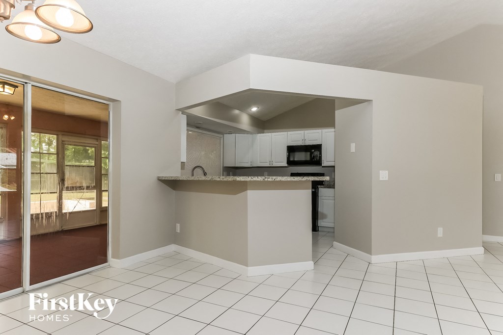 a kitchen with an island and a door to the living room