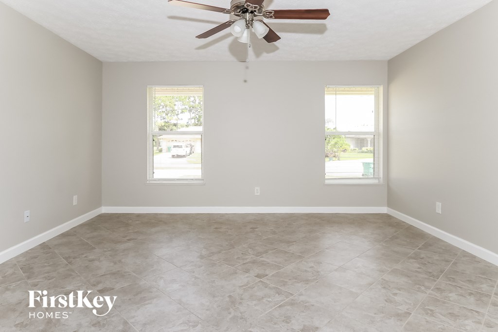 a clean and empty room with a ceiling fan