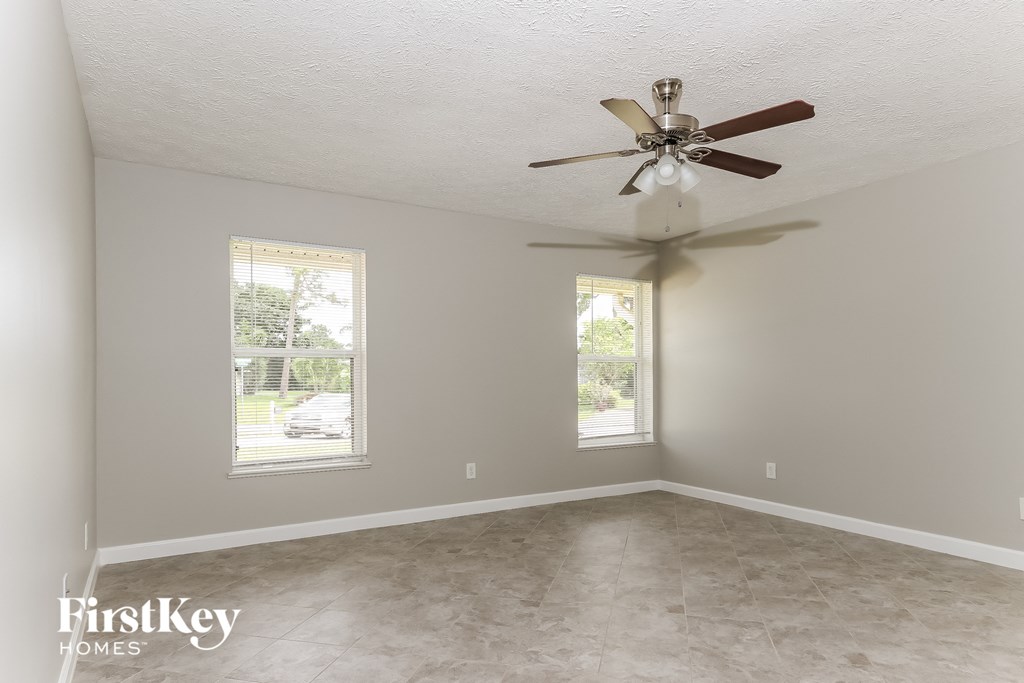 a empty room with a ceiling fan and a window