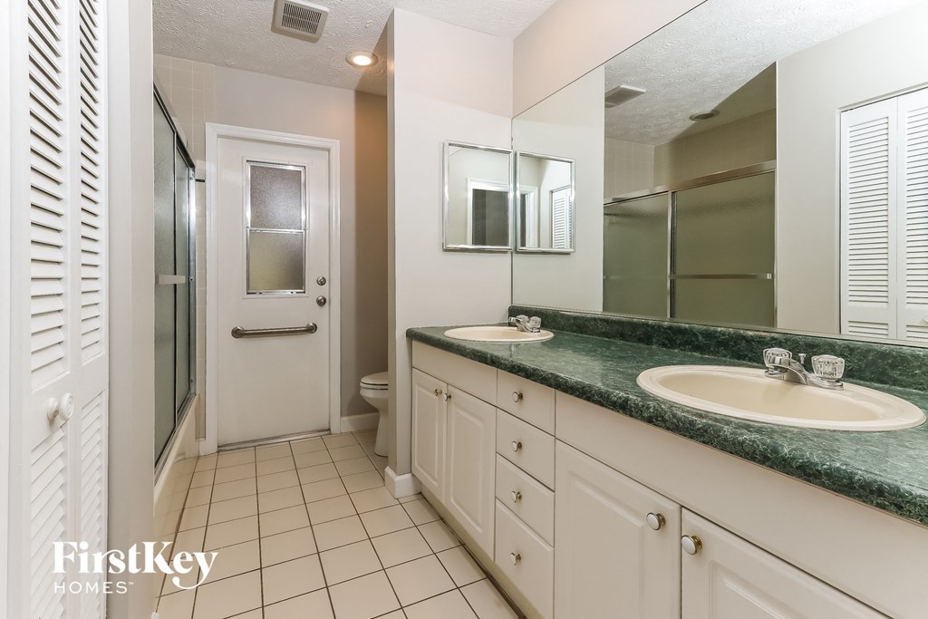 a bathroom with two sinks and a shower and a toilet
