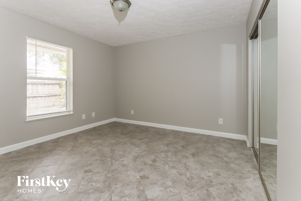 an empty room with a mirrored closet and a window