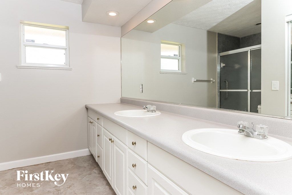a bathroom with two sinks and a large mirror