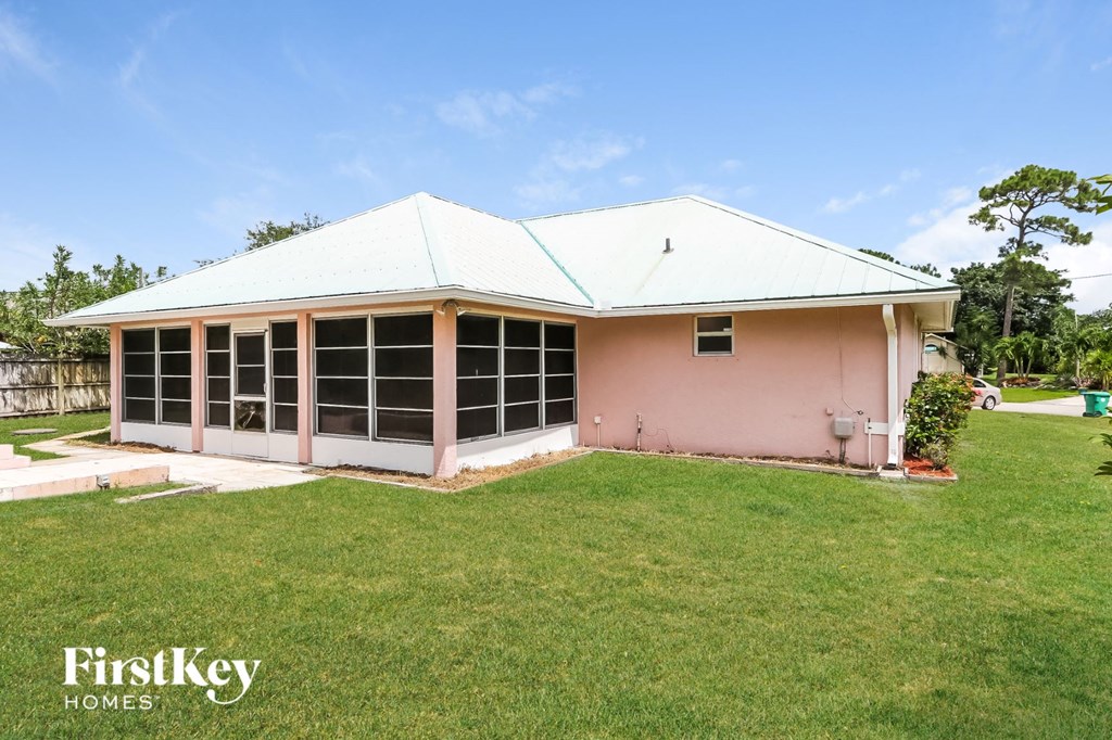 the front of a pink house with green grass and a yard