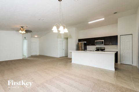 A spacious kitchen with a white countertop and a ceiling fan.