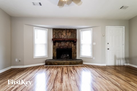 a living room with a fireplace and wooden floors