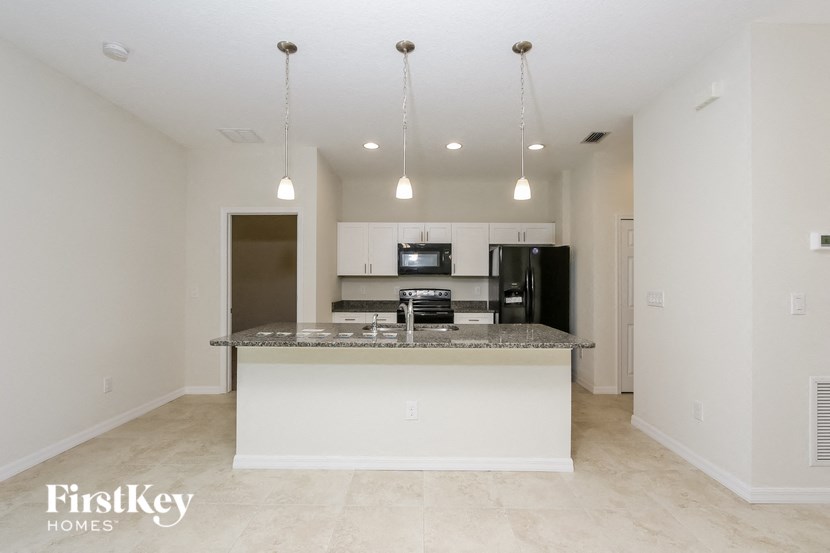 A kitchen with a granite countertop and a refrigerator.