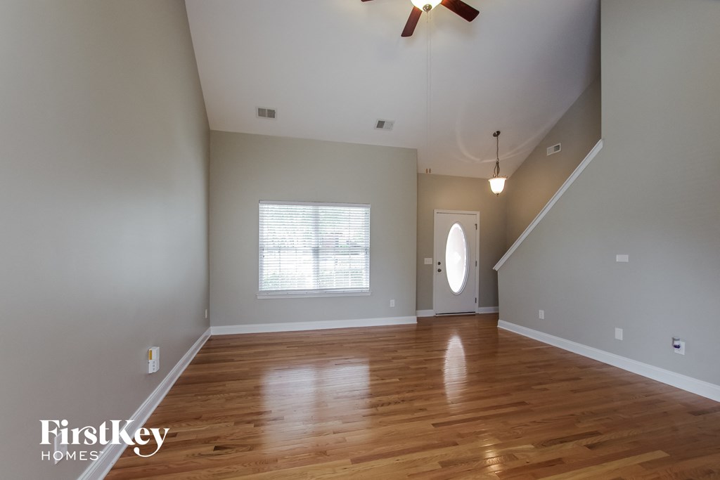 the living room with hardwood floors and a ceiling fan