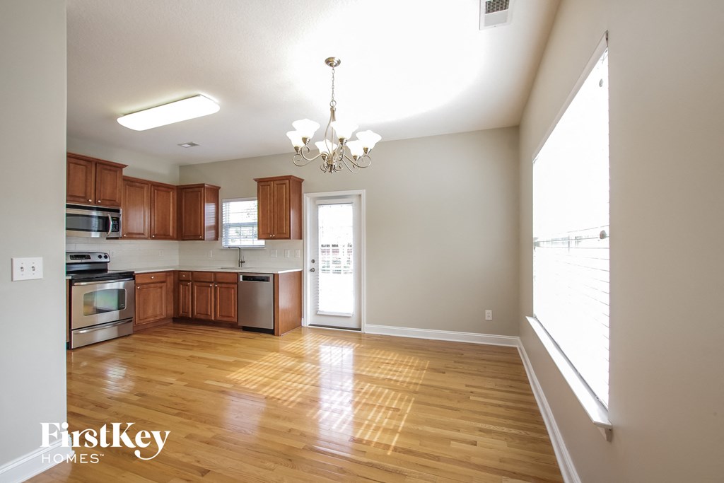 an empty kitchen with wood flooring and wooden cabinets
