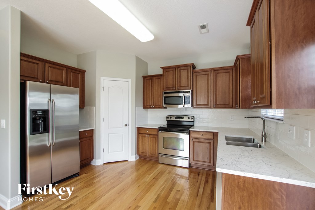 a kitchen with wooden cabinets and stainless steel appliances