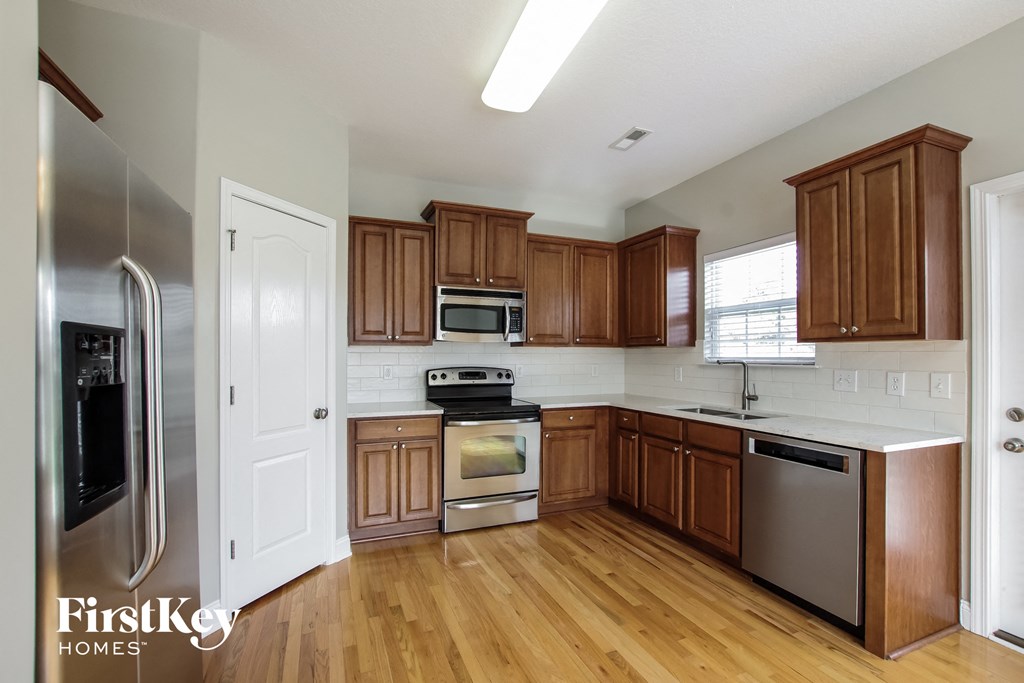 a kitchen with wooden cabinets and stainless steel appliances