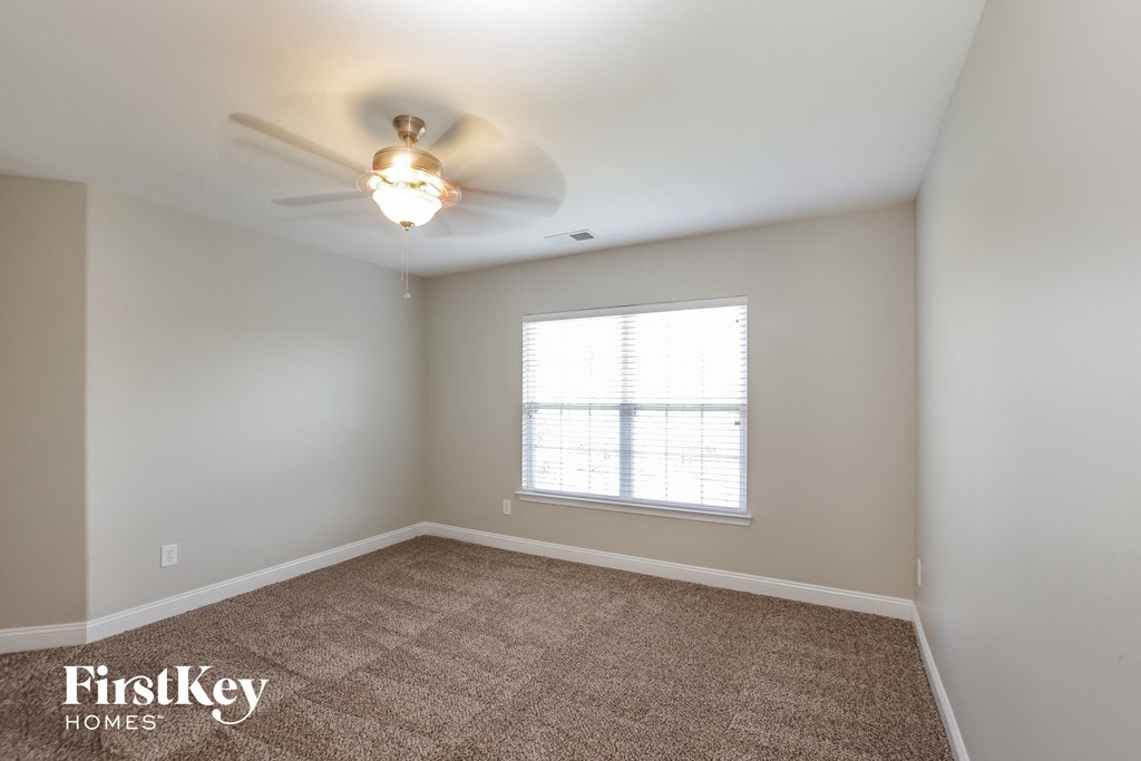 a bedroom with a ceiling fan and a window
