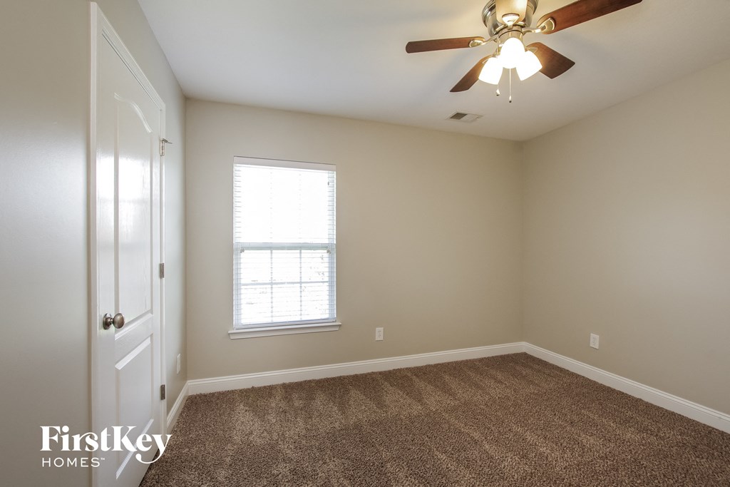 a bedroom with carpet and a ceiling fan