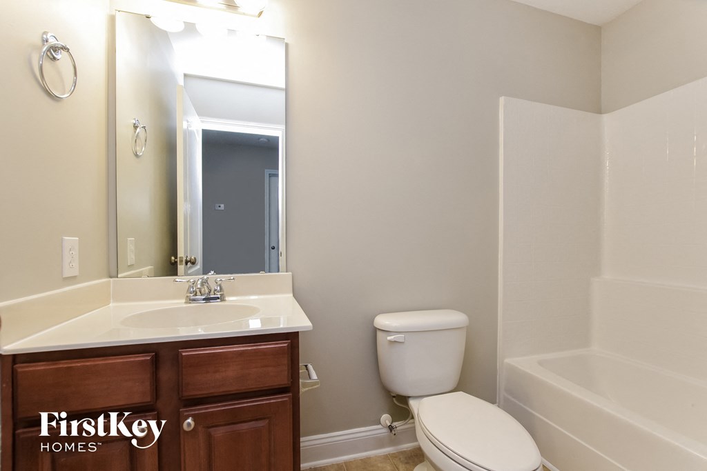 a bathroom with a toilet and a sink and a mirror