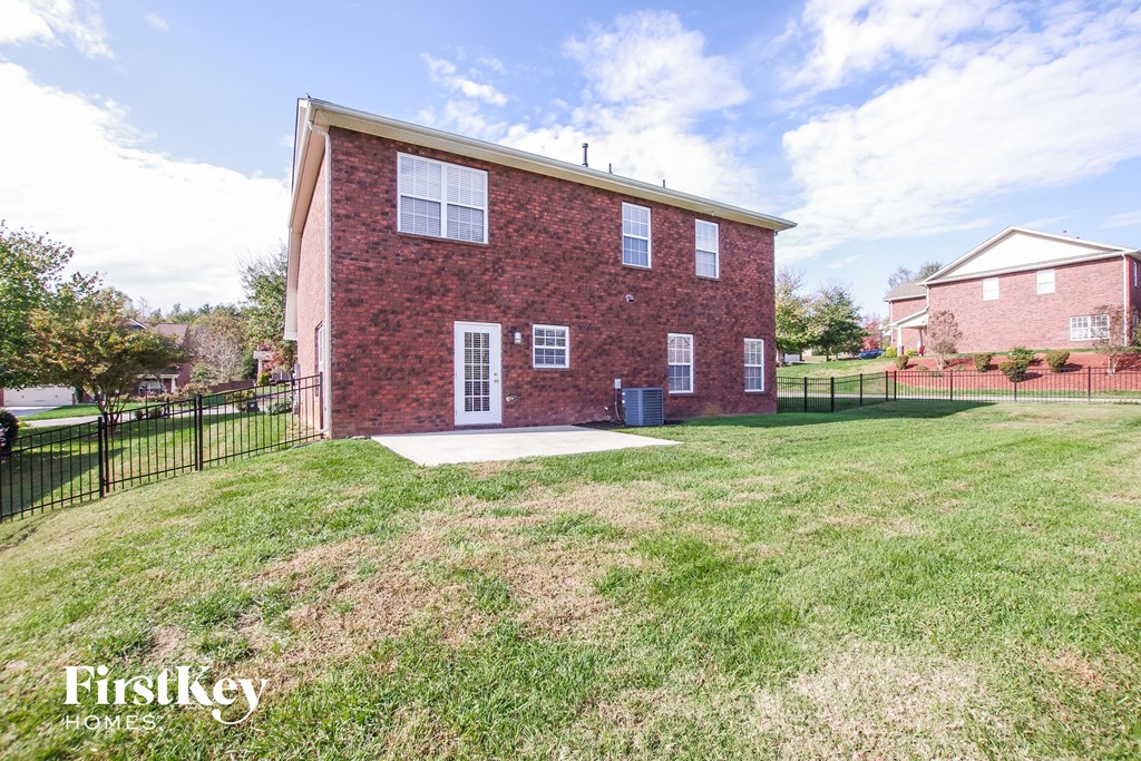 a brick house with a yard and a black fence
