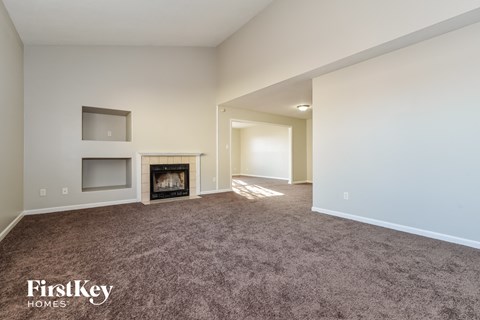 a living room with a carpeted floor and a fireplace