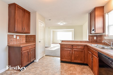 a kitchen with wooden cabinets and a sink and a window